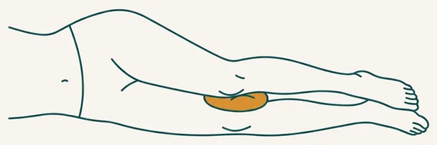 Dormeur sur le côté avec un coussin entre les genoux